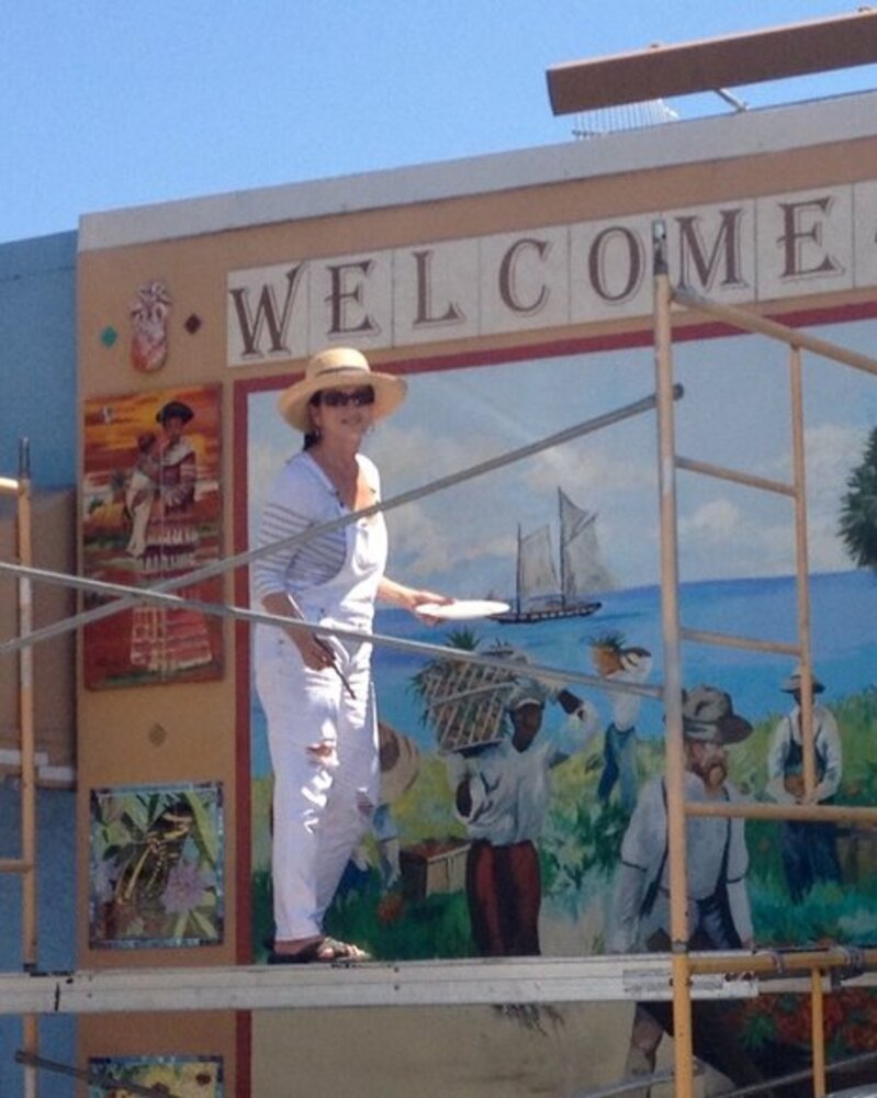 Maureen Fulgenzi on scaffolding painting the Downtown Stuart mural