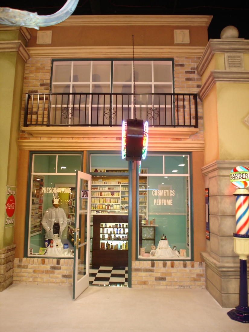 Corner storefront mural with striped awning and barber pole, car museum backdrop, Palm Beach, FL