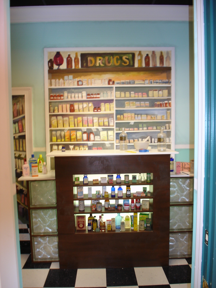 Pharmacy interior mural with painted drug-store shelving and product displays, car museum backdrop, Palm Beach, FL
