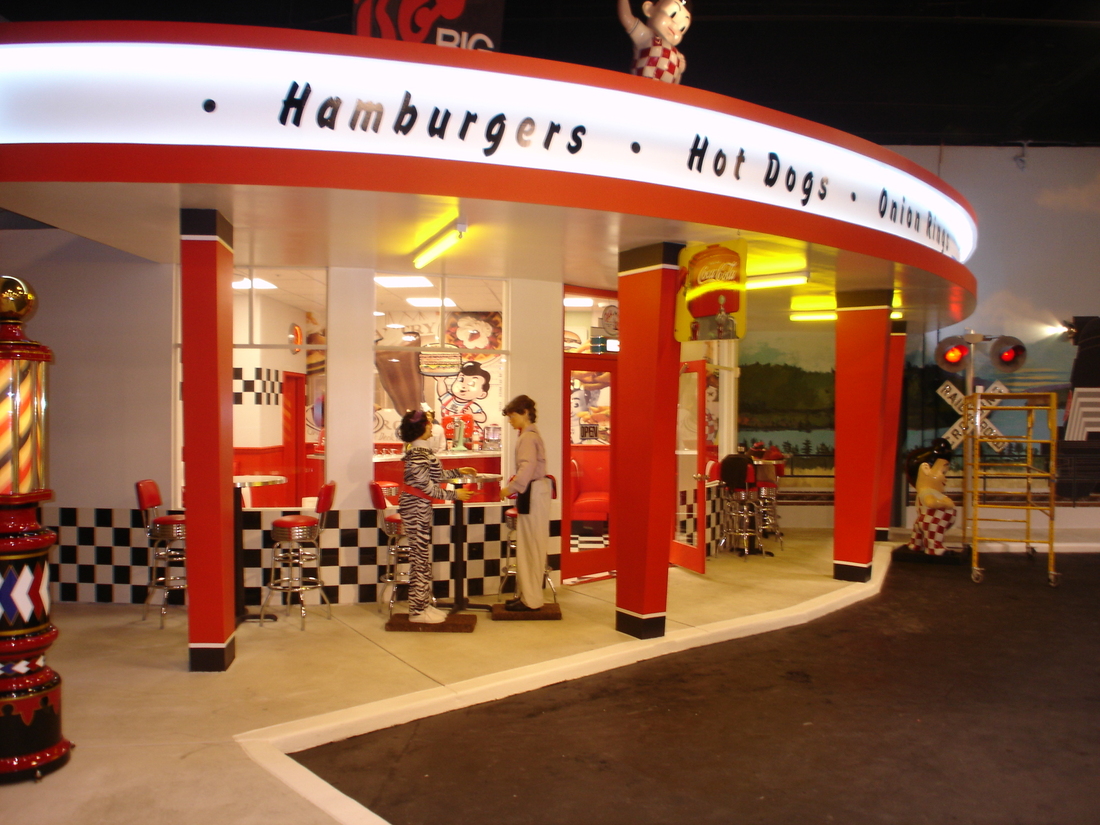Hamburger and hot dog stand mural with red-striped canopy, car museum backdrop, Palm Beach, FL