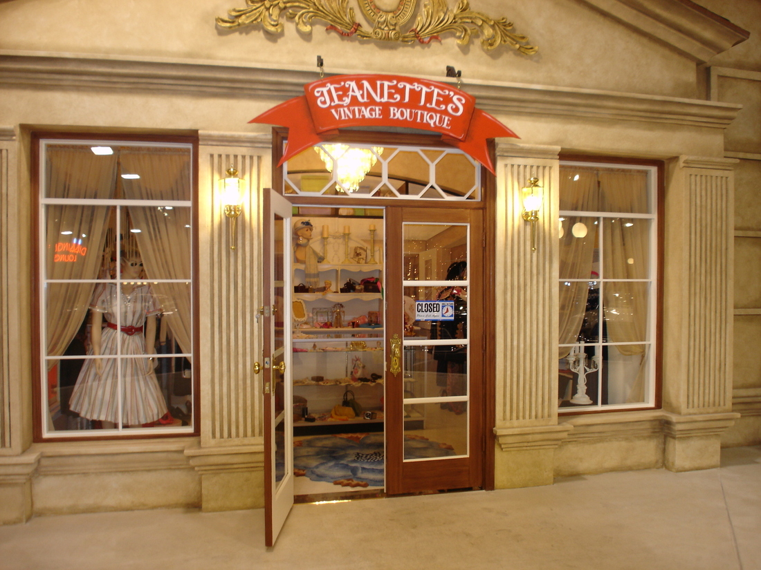 Vintage boutique storefront mural with a dress displayed in the window, car museum backdrop, Palm Beach, FL