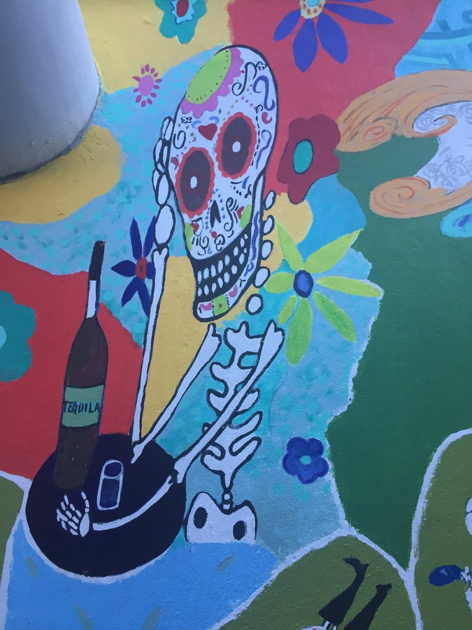 Painted sugar skull face with roses and a tequila bottle, exterior terrace mural, Palm Beach, FL