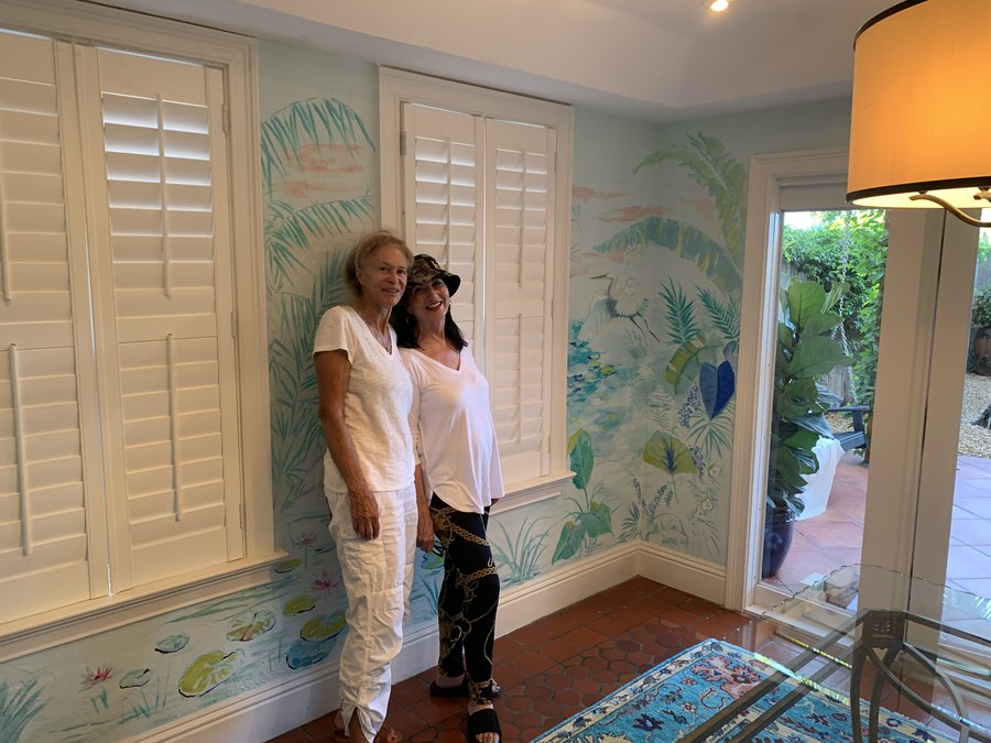Tropical foliage mural room view with pendant light and person for scale, Palm Beach, FL