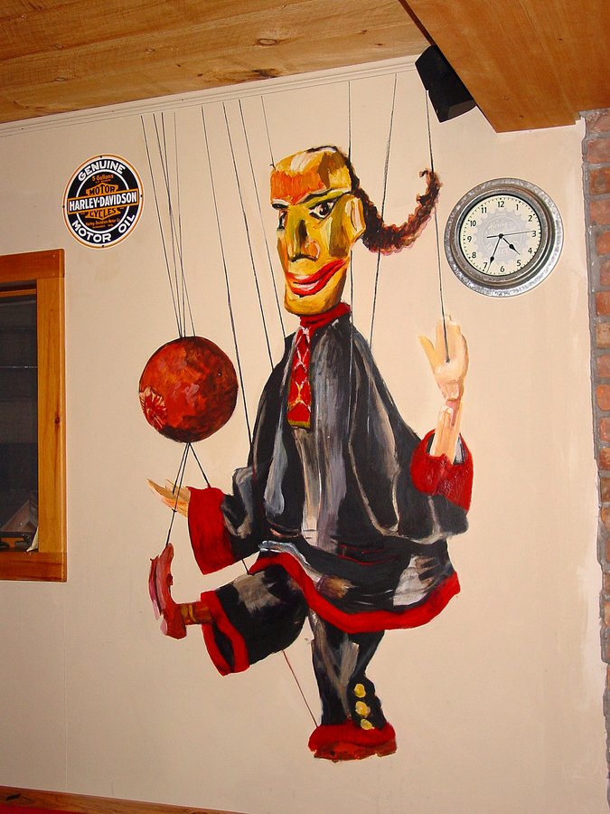 Marionette puppet mural detail beside a wall clock and Harley-Davidson sign, Palm Beach, FL
