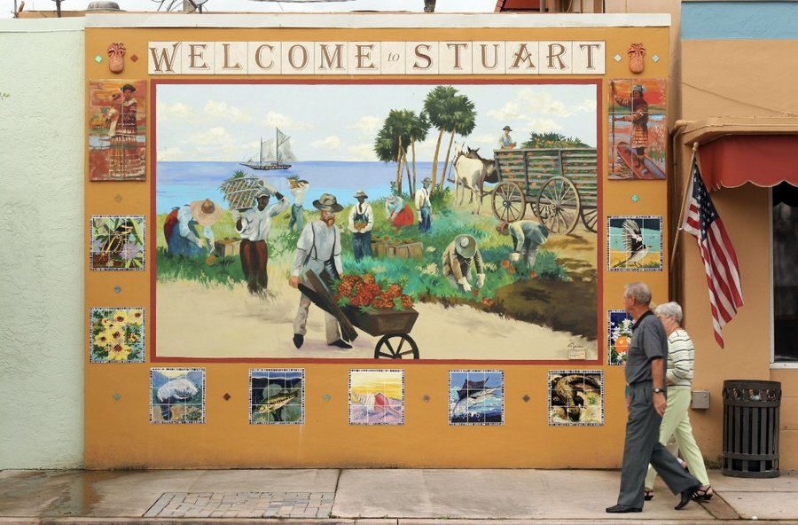 Full finished Stuart mural with a man and dog walking past, American flag visible, Palm Beach, FL