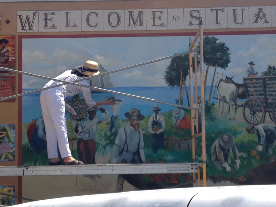 Artist on ladder painting figures into the Stuart mural, in-progress, Palm Beach, FL