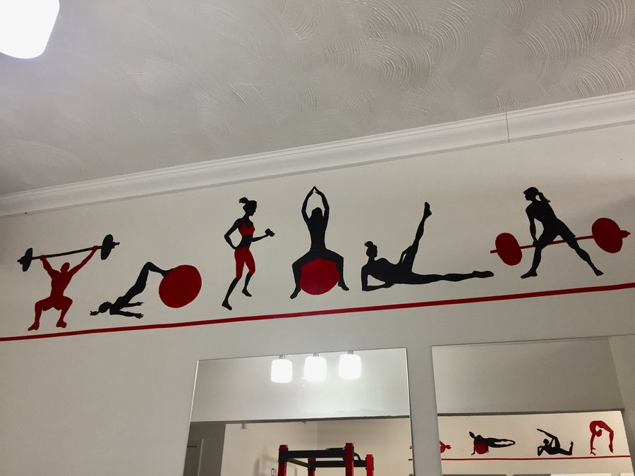 Full straight-on view of the gym mural border above the mirrored wall, Palm Beach, FL