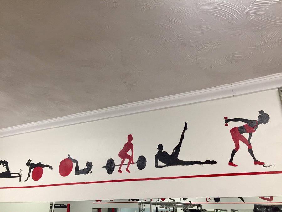 Reclining leg-lift and seated silhouette figures painted along the gym mural border, Palm Beach, FL
