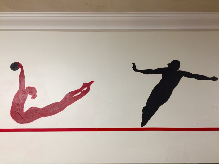 Backbend and stability-ball silhouette figures painted along the gym mural border, Palm Beach, FL