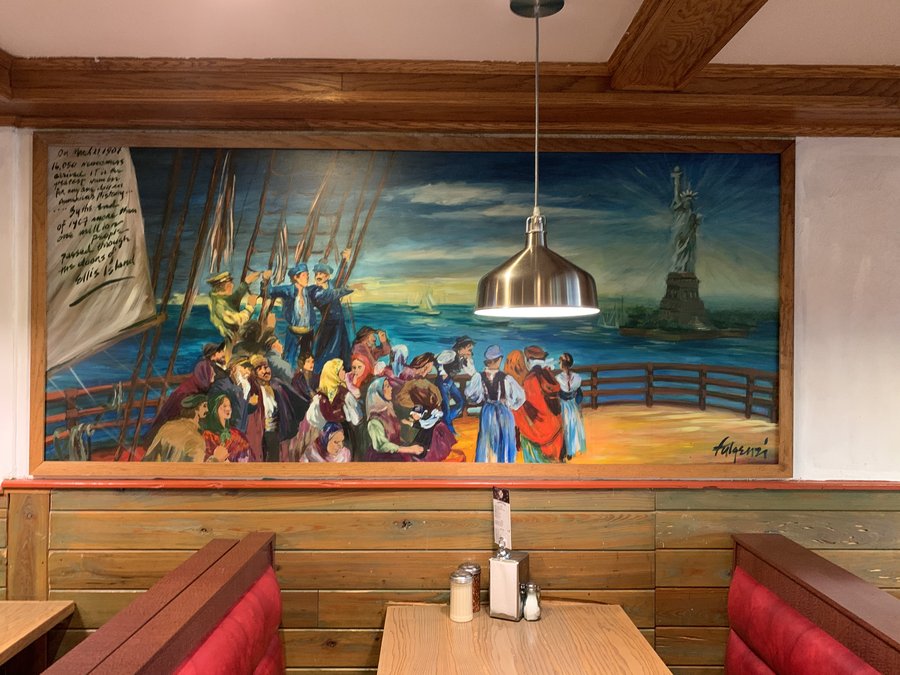 Ellis Island immigrant arrival scene mural with the Statue of Liberty, signed by Maureen Fulgenzi, restaurant booth wall, Palm Beach, FL