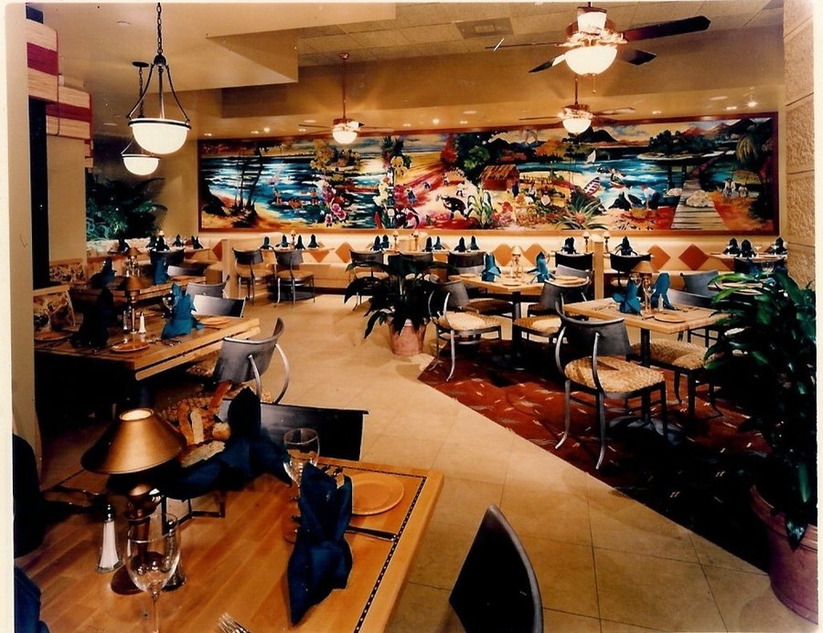 Restaurant dining room showing the full run of tropical landscape mural panels along the wall, Palm Beach, FL