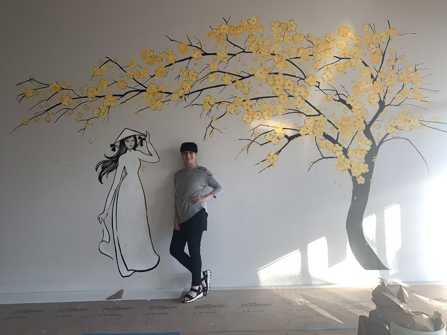 Maureen Fulgenzi posed beside the cherry blossom tree mural outline, early stage, Pho and Rolls, Palm Beach, FL
