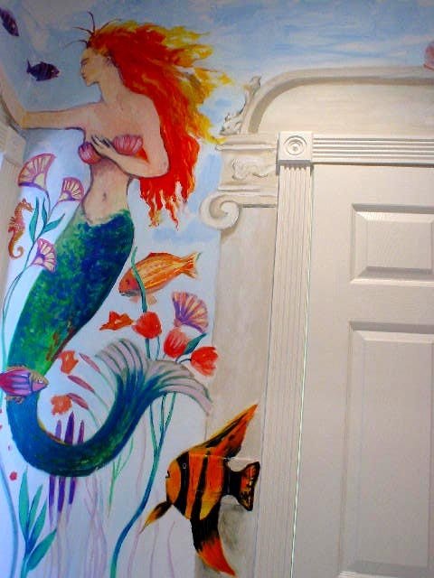 Mermaid mural detail with flowing red hair beside the door frame, Palm Beach, FL