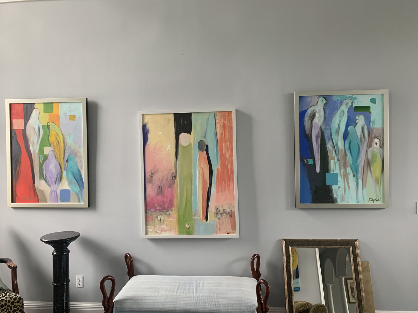 Three abstract paintings by Maureen Fulgenzi grouped gallery-style on a grey living room wall, Palm Beach, FL