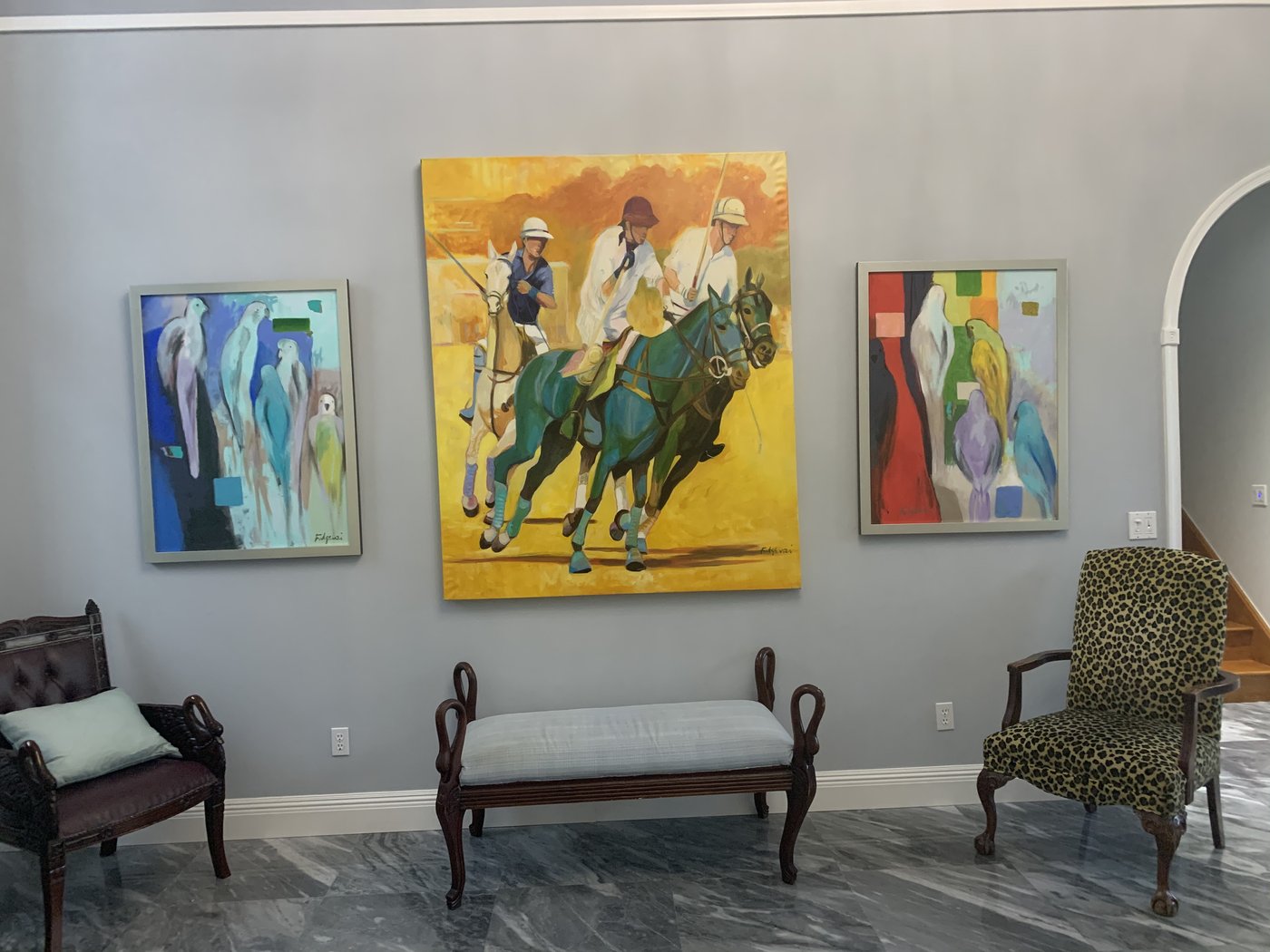 Gallery wall of three paintings by Maureen Fulgenzi, including a polo scene, in a Palm Beach entry foyer