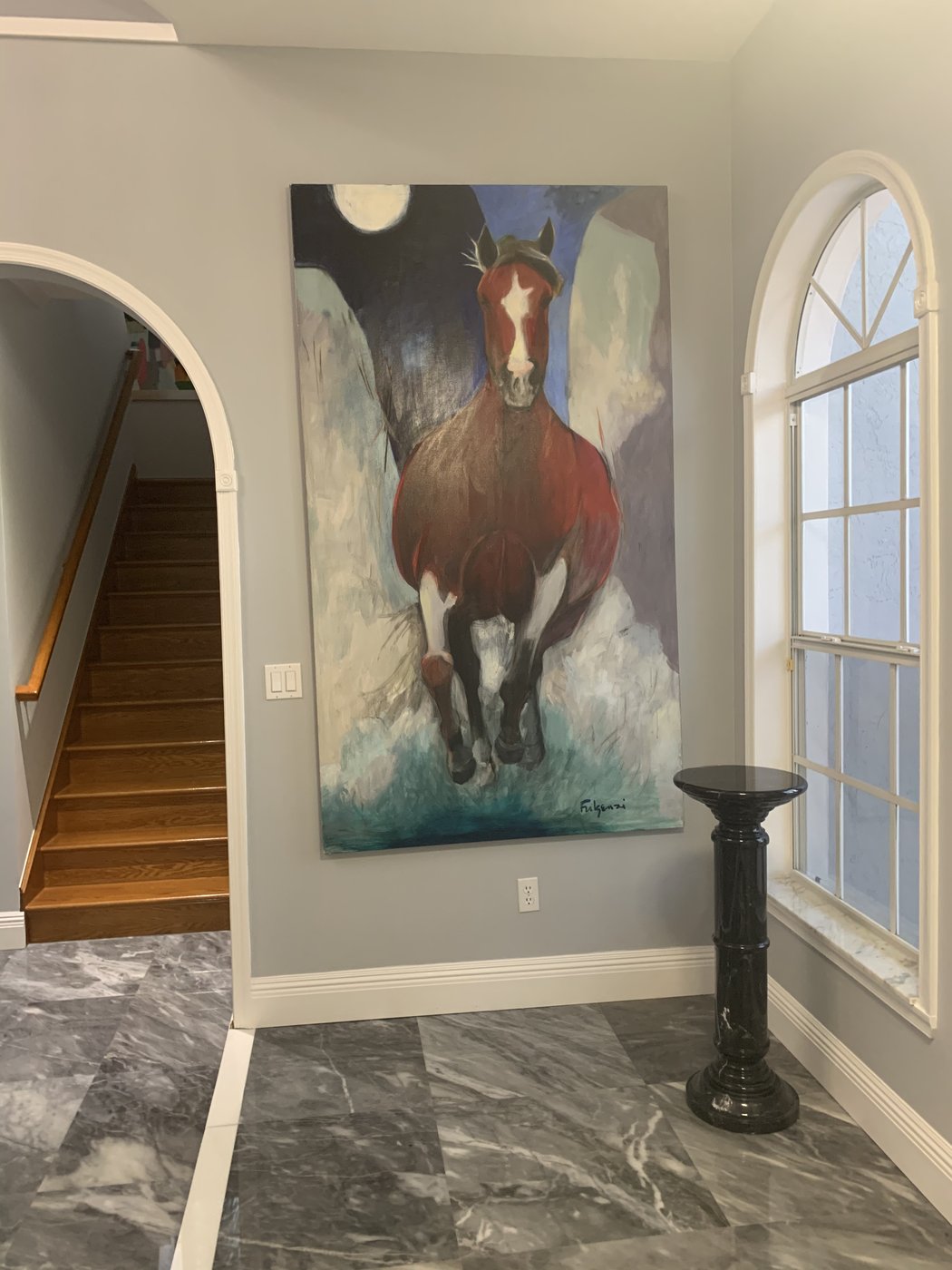 Realistic horse painting by Maureen Fulgenzi in a stairwell alcove beneath an arched window, Palm Beach, FL