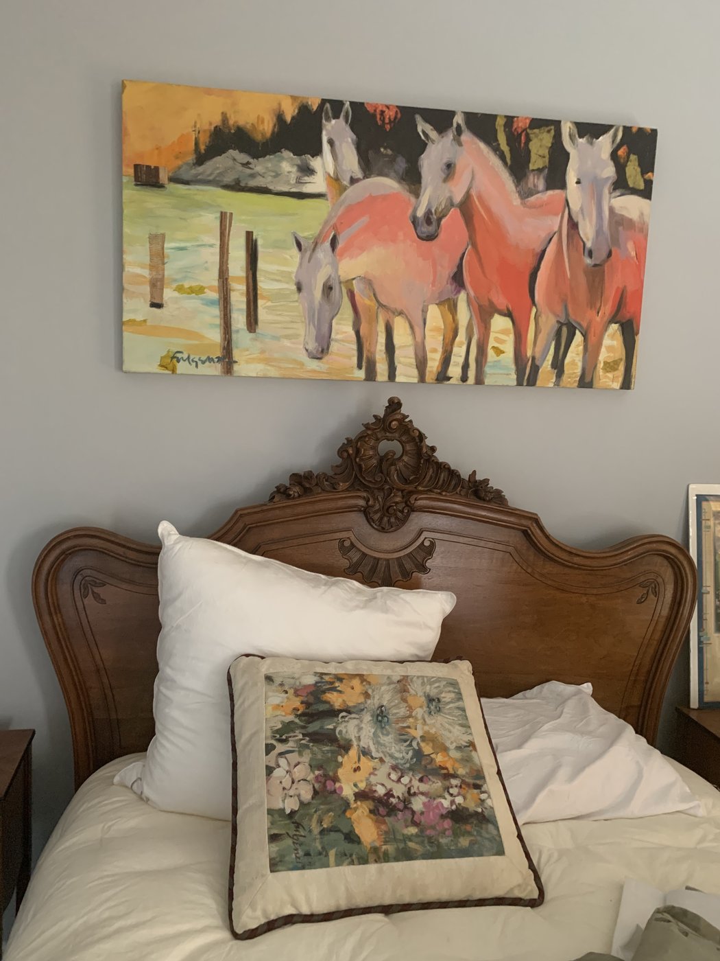 Realistic horses painting by Maureen Fulgenzi above a wood headboard with a floral throw pillow, Palm Beach, FL
